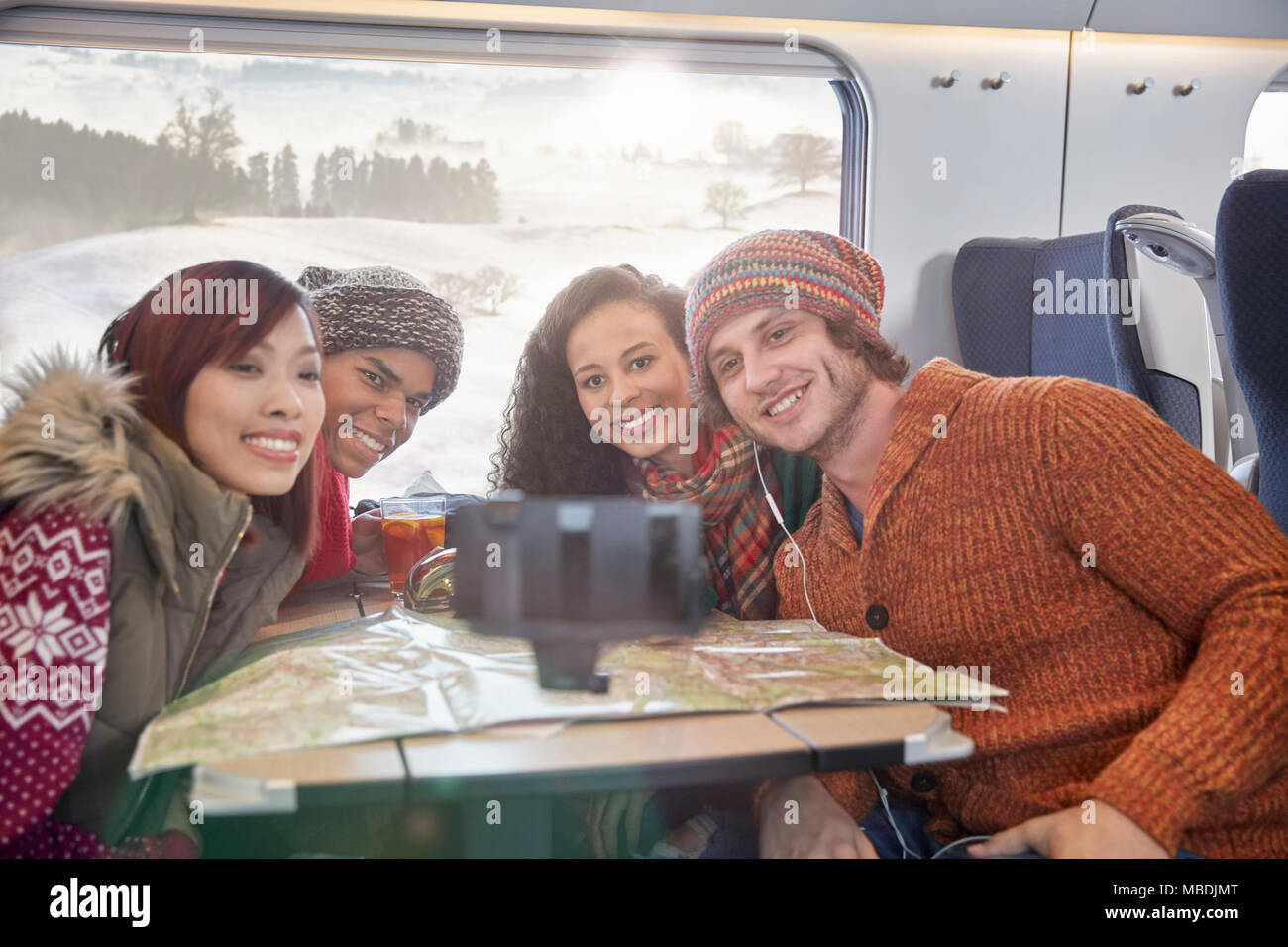 Glückliche junge Freunde mit Karte unter selfie mit selfie Stick auf Personenzug Stockfoto