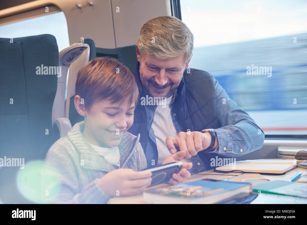 Vater und mit smart phone auf personenzug Sohn Stockfoto