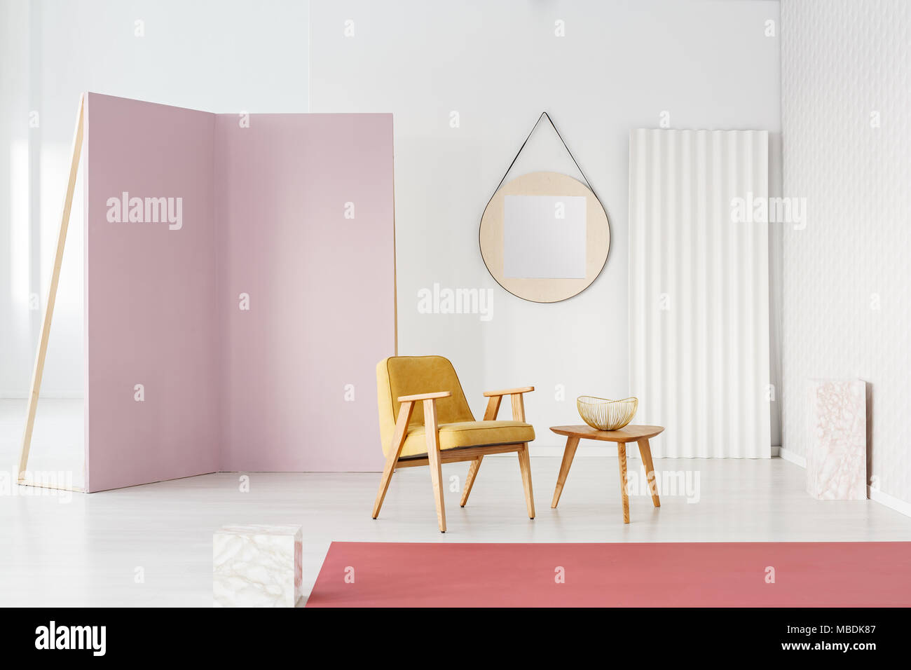 In Pastelltönen Foto Studio Einrichtung mit gelben Sessel, bewegliche, lila Wand- und runden Spiegel Stockfoto
