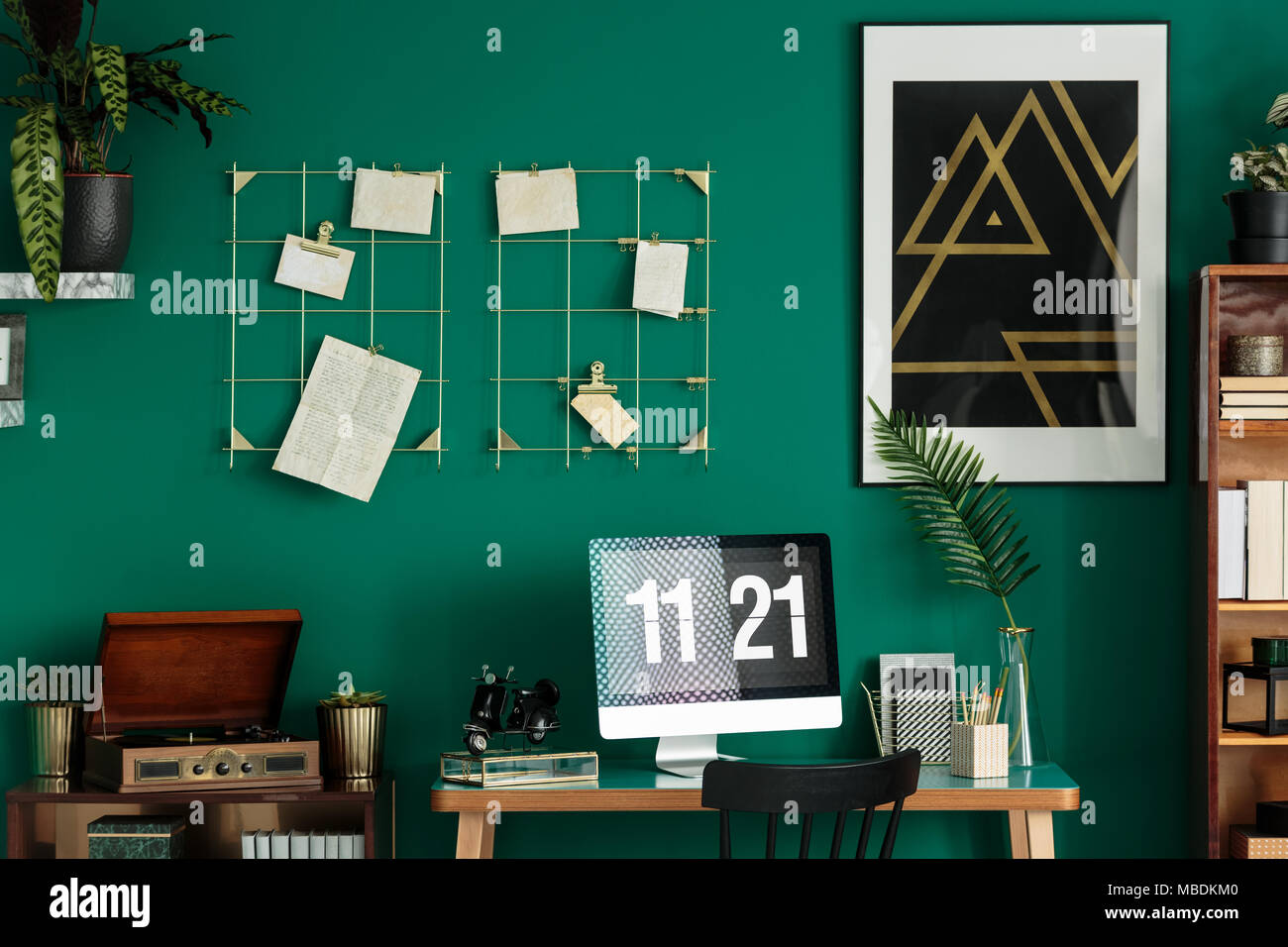 Schwarz und gold Poster mit geometrischen Muster an der Wand hängen in grün Innenraum mit retro Grammophon und Computer Stockfoto