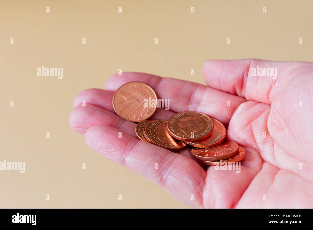 Weibliche Hand einige einen Penny Britische Pfund Münzen Stockfoto
