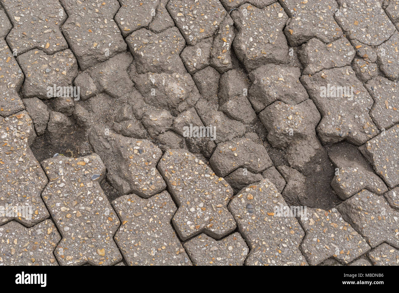 Gebrochene Abschnitt von W-block Interlocking ebnet - mögliche Metapher für fehlerhafte Links, "gebrochen", Breaking Apart, aufbrechen, potholed. Stockfoto