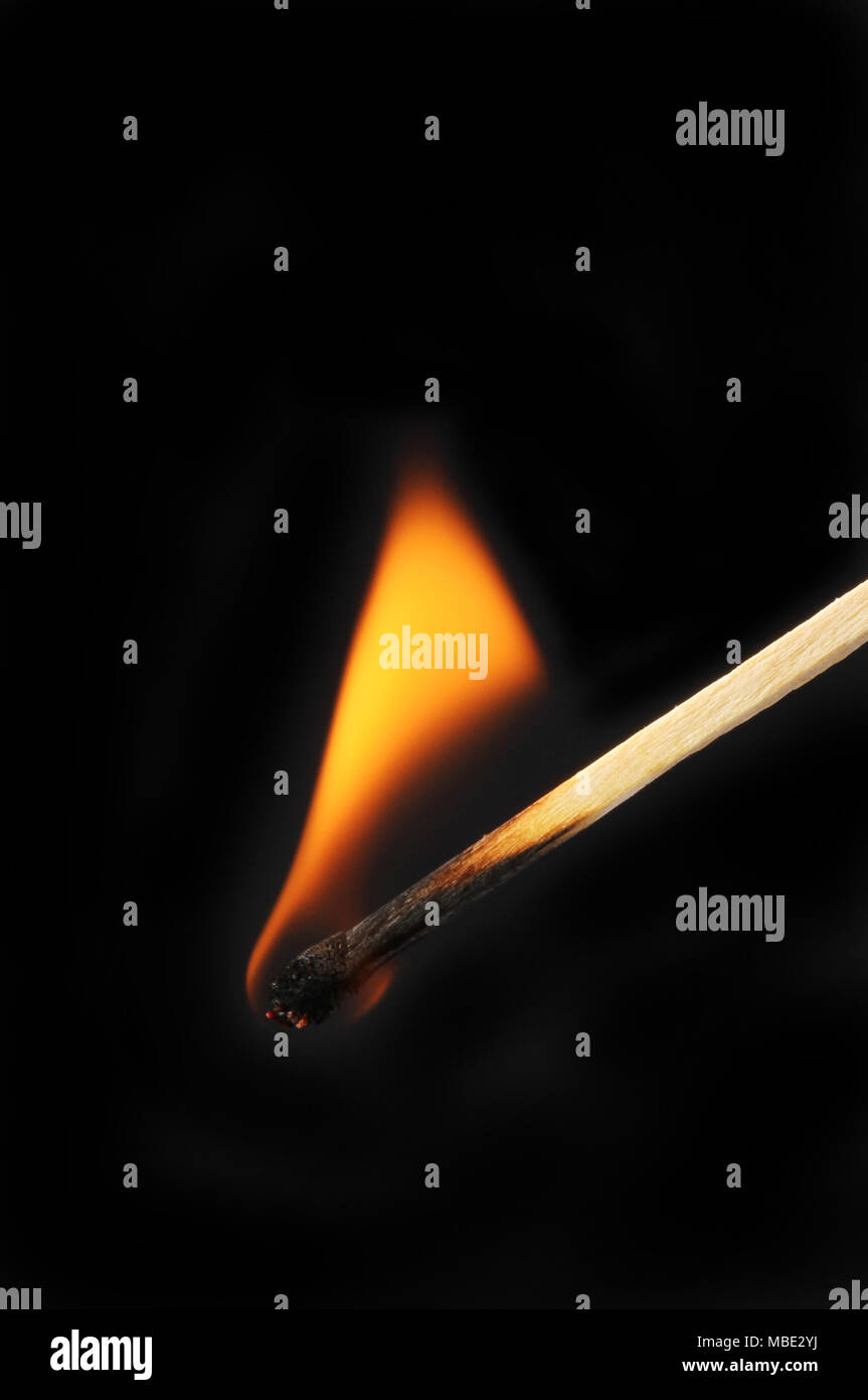 Brennende Streichholz vor einem schwarzen Hintergrund Stockfoto