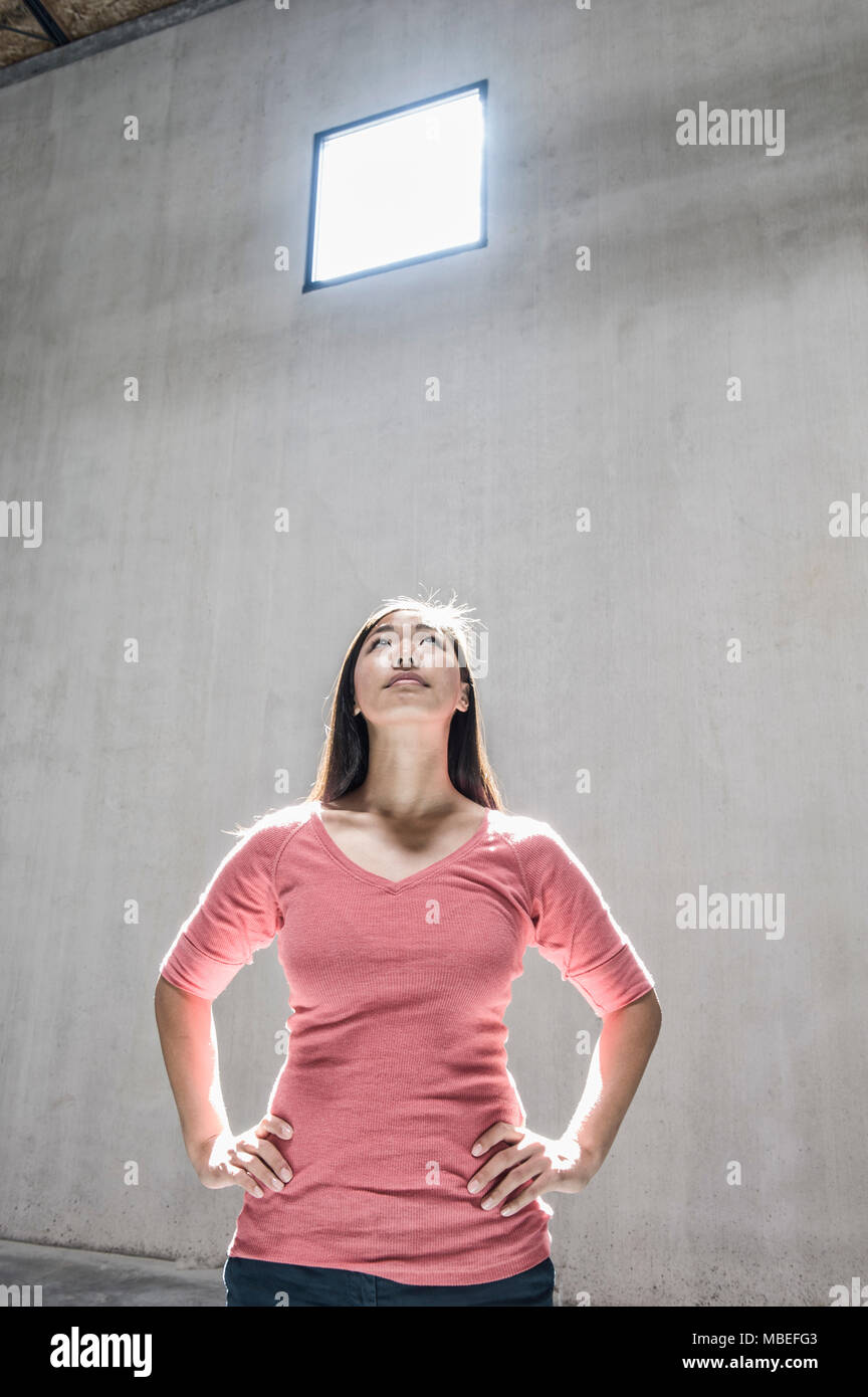 Asiatische Frau, die unter dem Licht von einem Fenster in ein neues Lager. Stockfoto