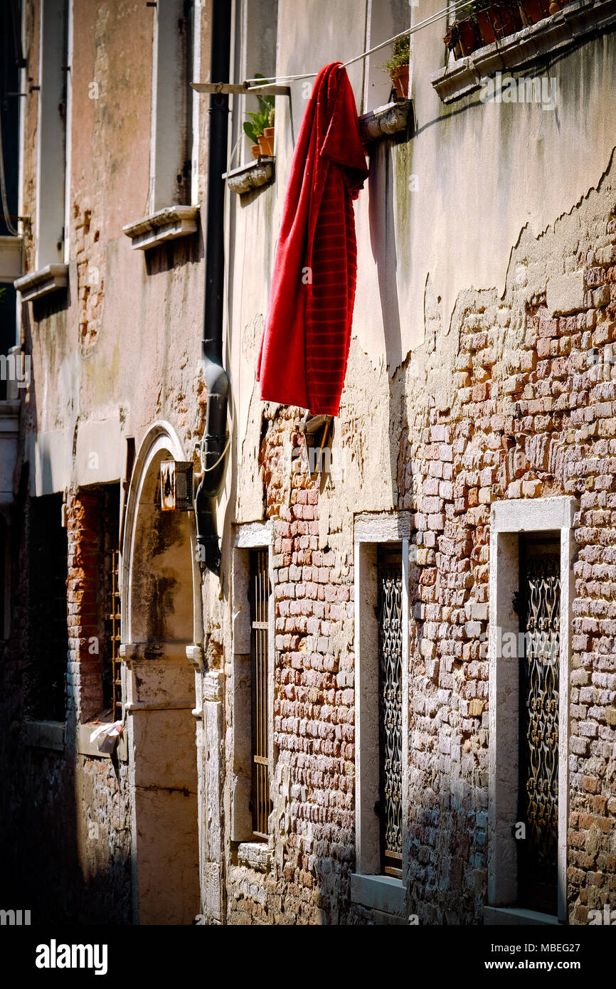 Eine rote Decke außerhalb eines Fensters in Venedig Italien hängen Stockfoto