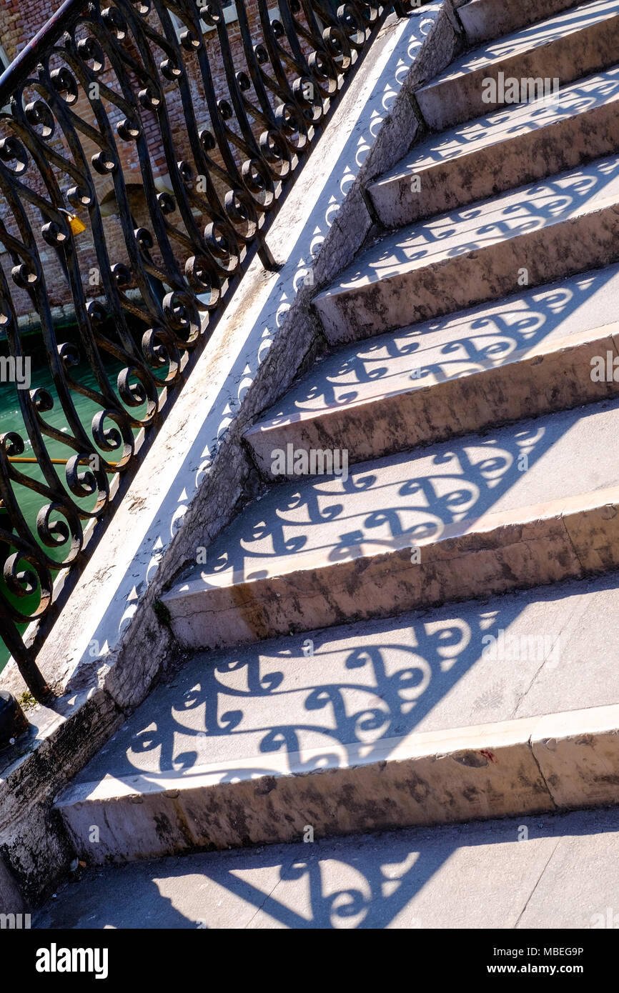 Eine Reihe von Steintreppe mit verzierten Geländer und Schatten Stockfoto