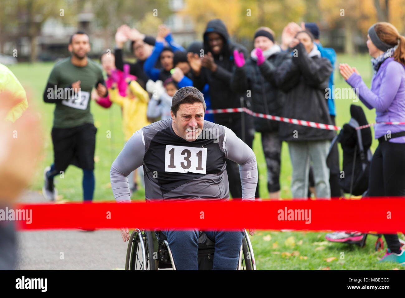 Bestimmt Mann im Rollstuhl Charity Rennen kurz vor der Ziellinie in Park Stockfoto