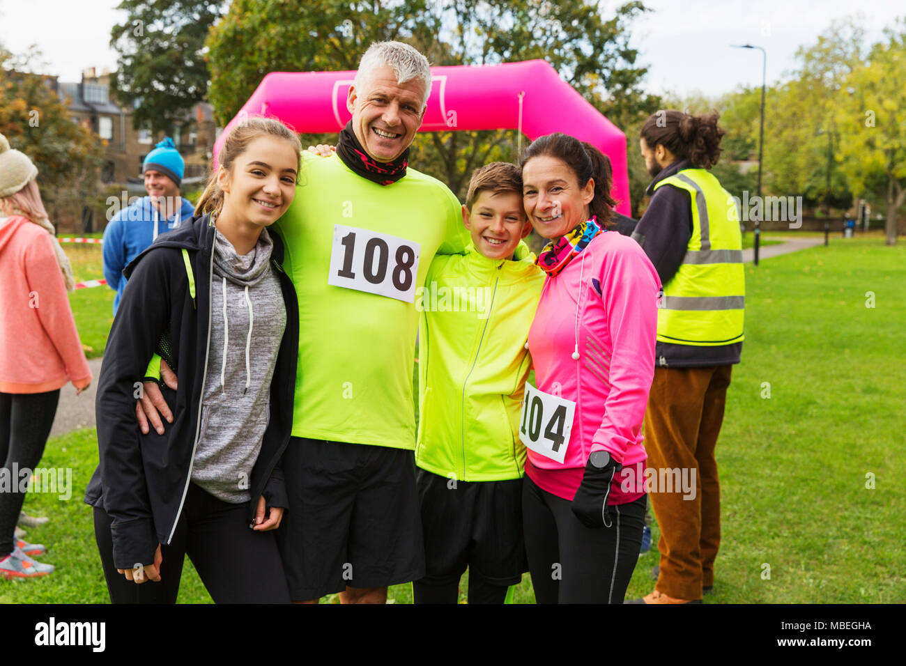Porträt Lächeln Familie Läufern an spendenlauf in Park Stockfoto