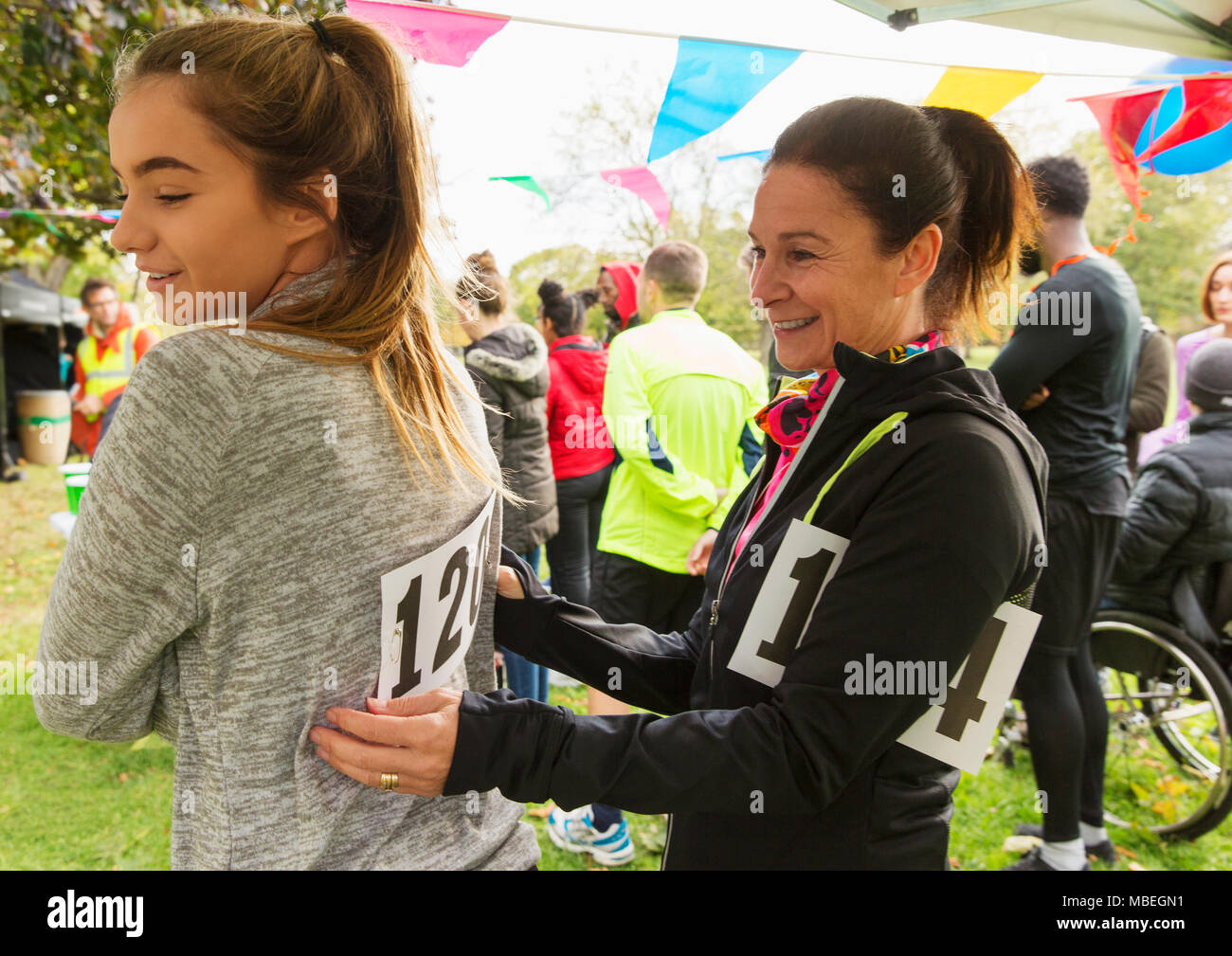 Mutter pinning Marathon bib auf die Tochter, die an der Spendenaktion in Park Stockfoto