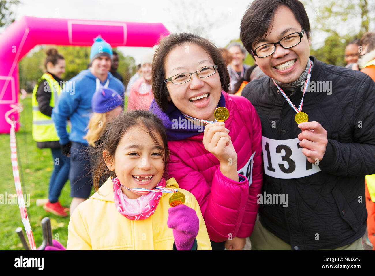 Portrait begeisterte Familie Läufer mit Medaillen bei Charity Run Stockfoto