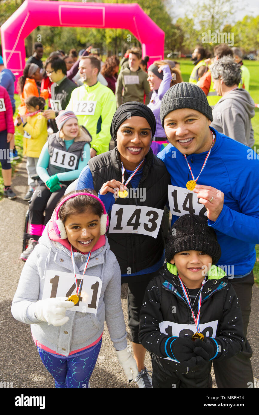 Porträt Lächeln Familie mit Medaillen bei Charity Run Stockfoto