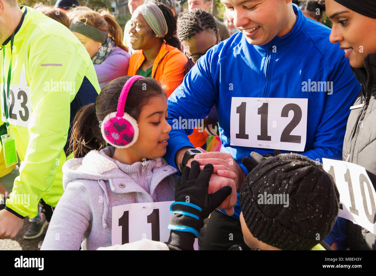 Familie Läufer prüfen smart Watch at Charity Run Start Stockfoto