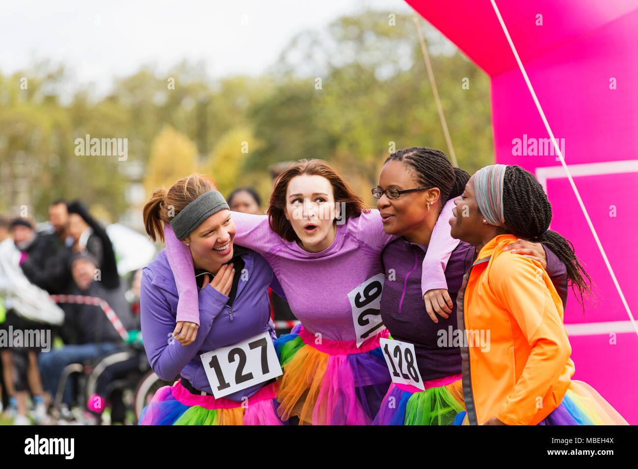 Happy Läuferinnen umarmen bei spendenlauf Finish Line Stockfoto