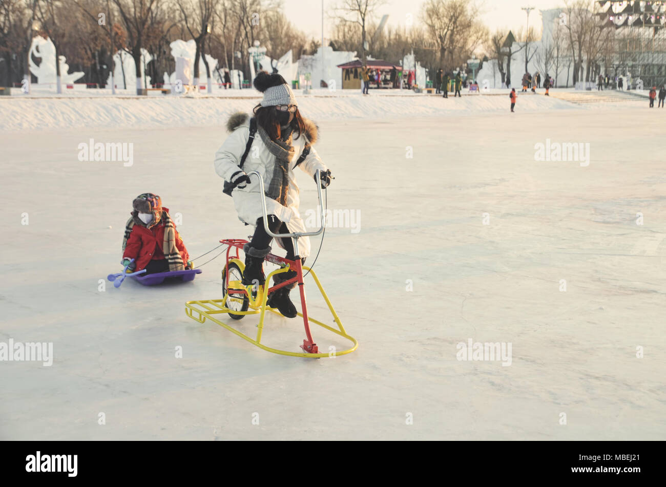 Touristen spielen und Reiten Fahrrad auf der Oberfläche von gefrorenen See in Sun Island Scenic Area, Harbin Stockfoto