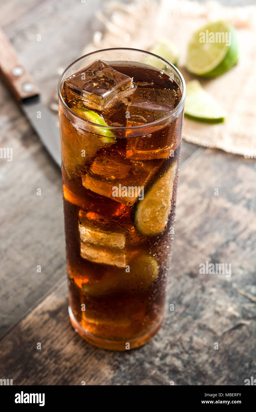 Cuba Libre. Cocktail mit Rum, Limetten und Eis auf Holztisch. Stockfoto