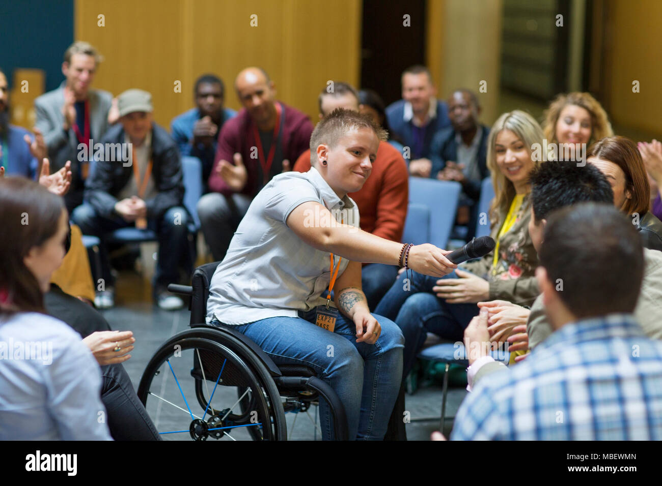 Weibliche Sprecher im Rollstuhl, Mikrofon, um Publikum Stockfoto