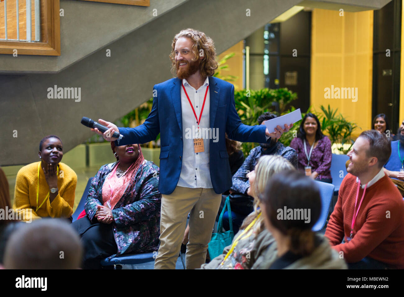 Lächelnd Sprecher männlich mit Mikrofon zu sprechen Konferenz Publikum Stockfoto