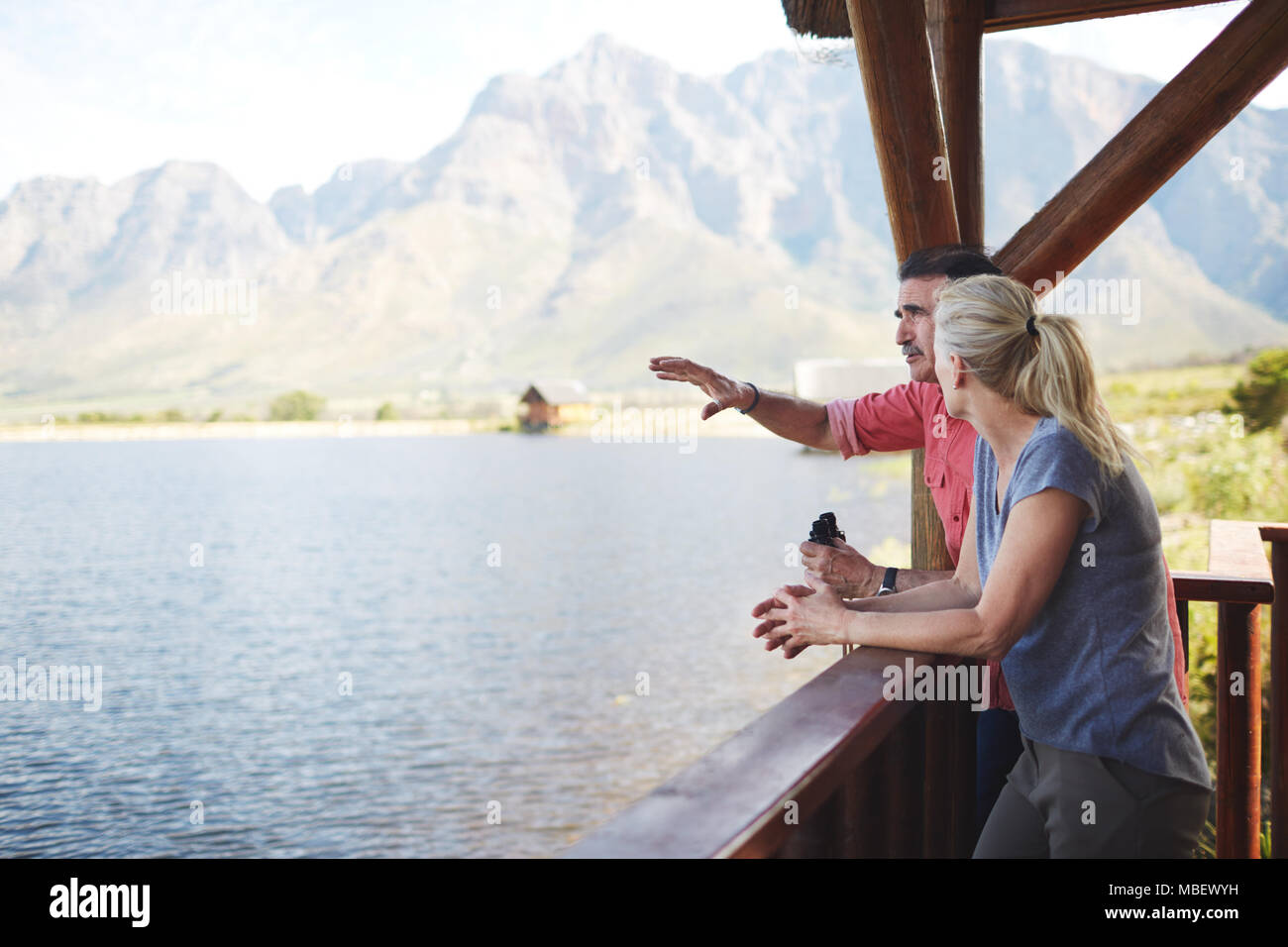 Paar mit Fernglas mit Seeblick vom Balkon. Stockfoto