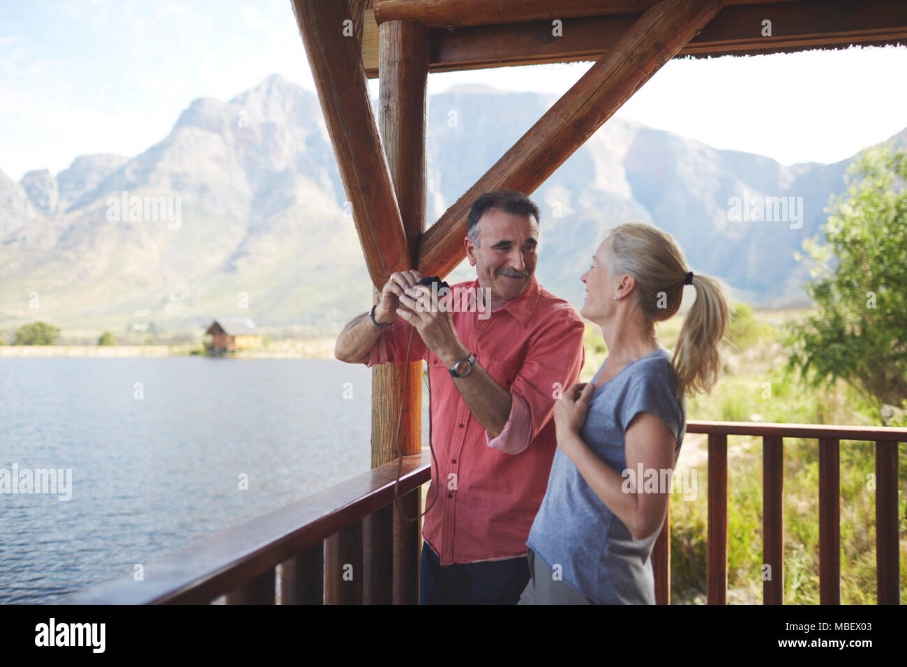 Glückliches Paar mit Fernglas mit Seeblick vom Balkon. Stockfoto