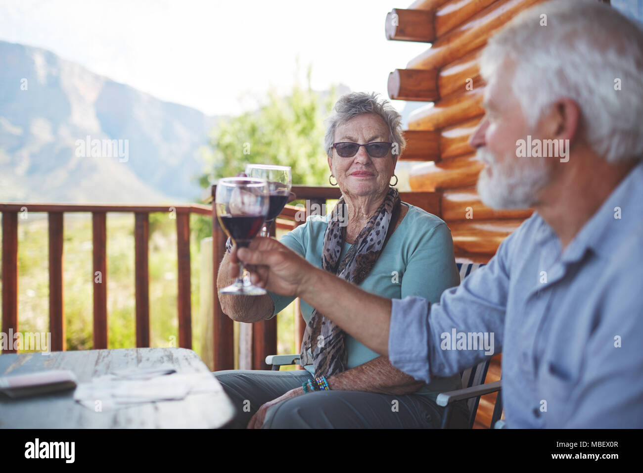 Active Senior Paar toasten Rotwein Gläser auf dem Balkon Stockfoto