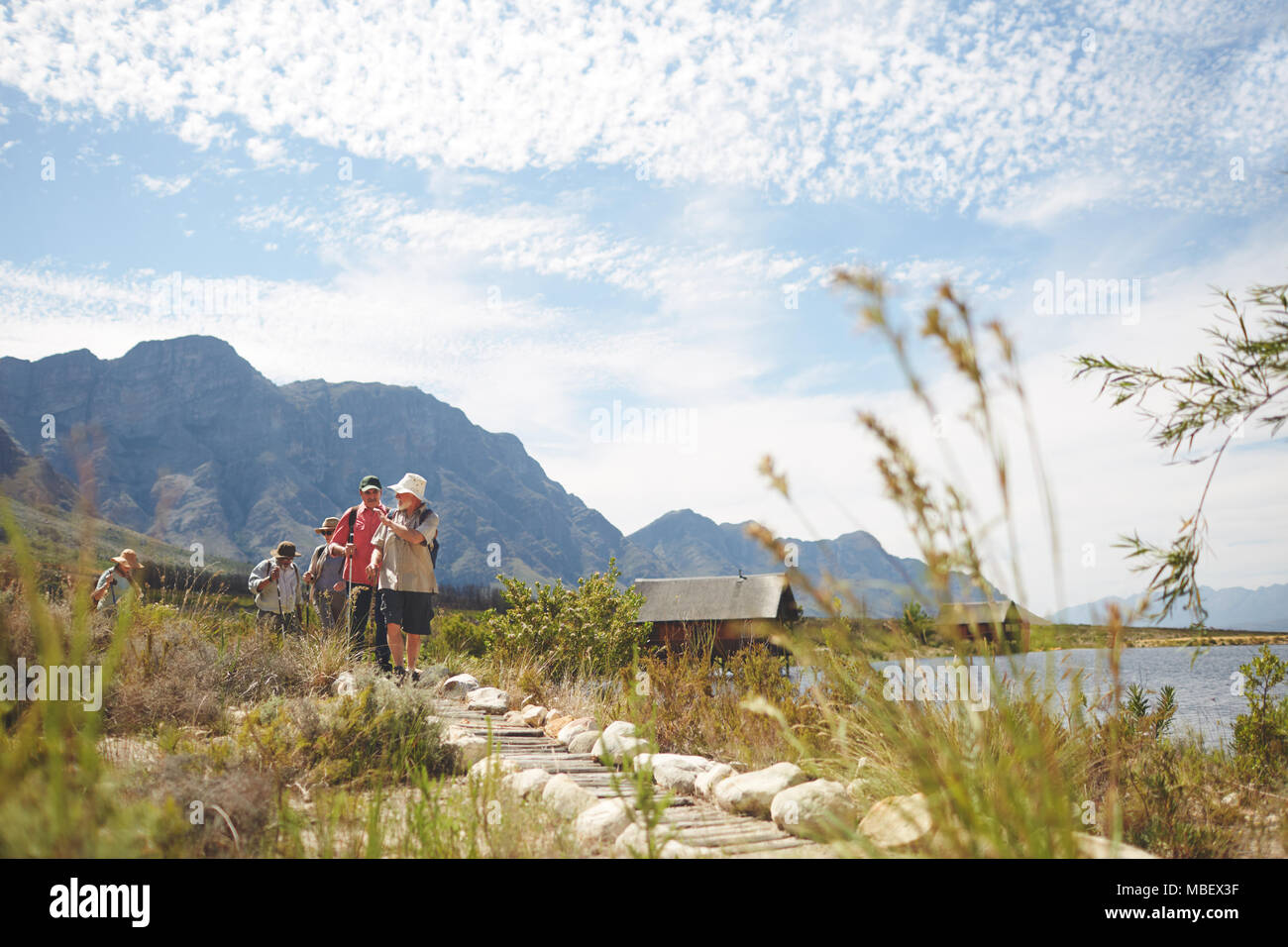Freunde Wandern auf Fußweg entlang sonniger Sommer See Stockfoto