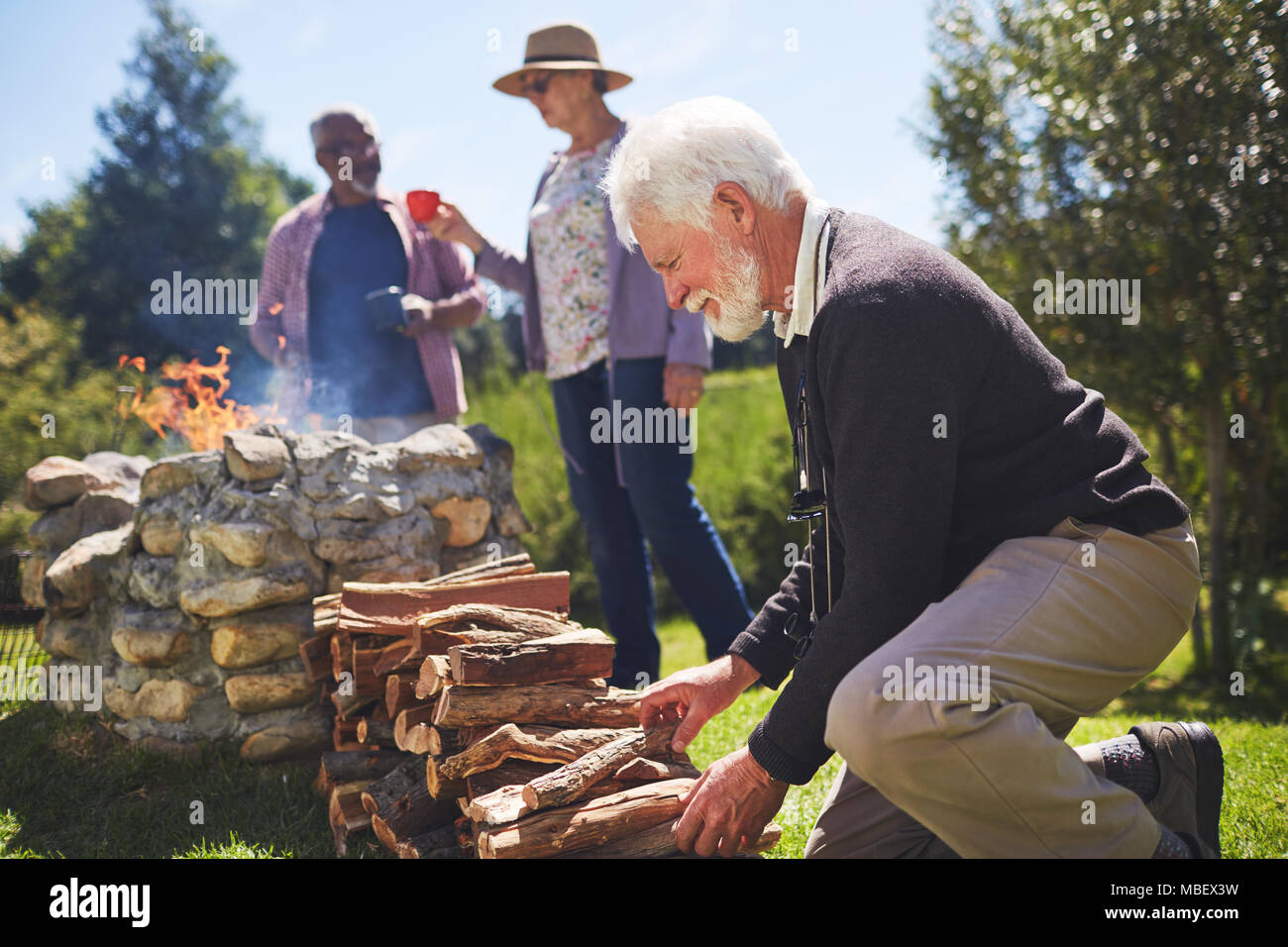Aktive ältere Menschen stapeln Brennholz Stockfoto