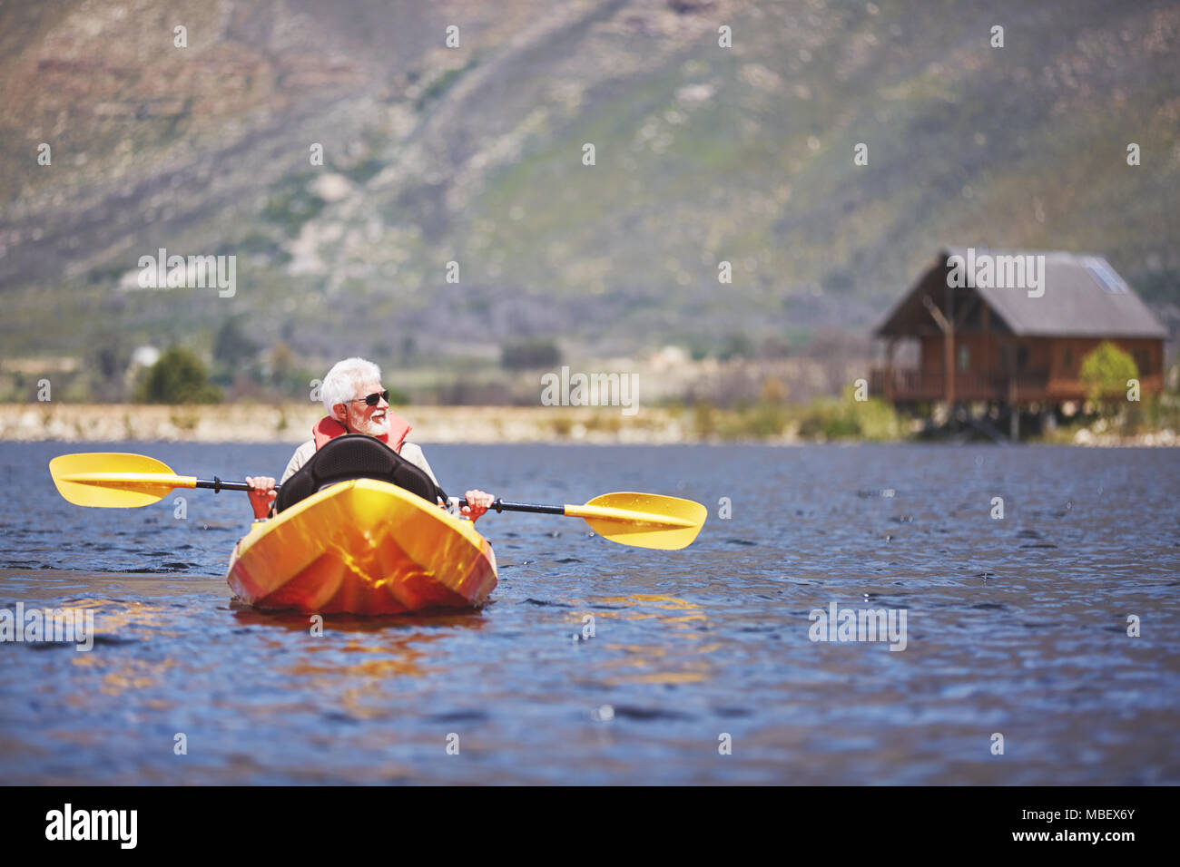 Älterer mann Kajak auf sonnigen Sommer See Stockfoto