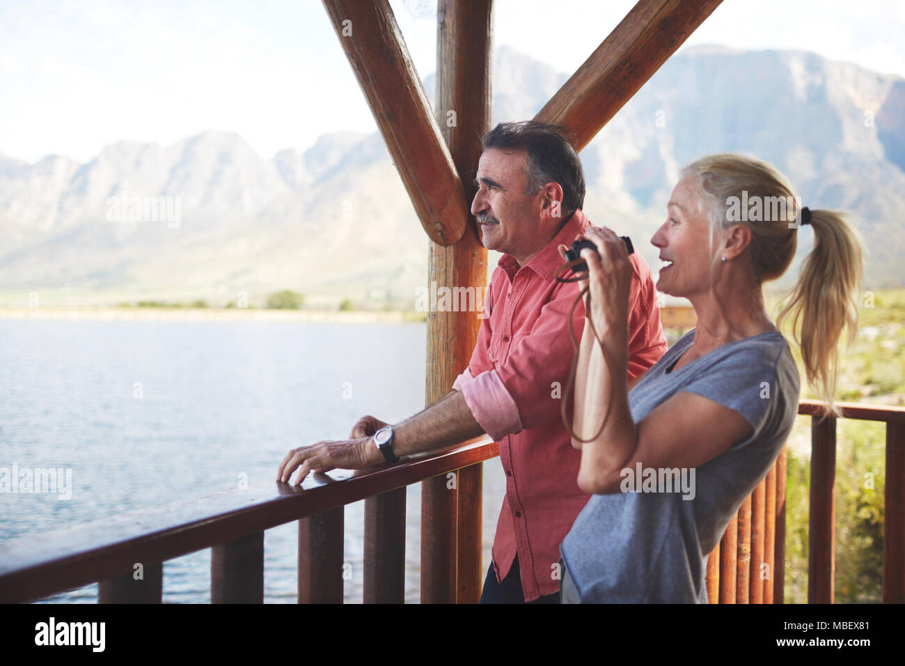 Paar mit Fernglas mit Seeblick vom Balkon. Stockfoto