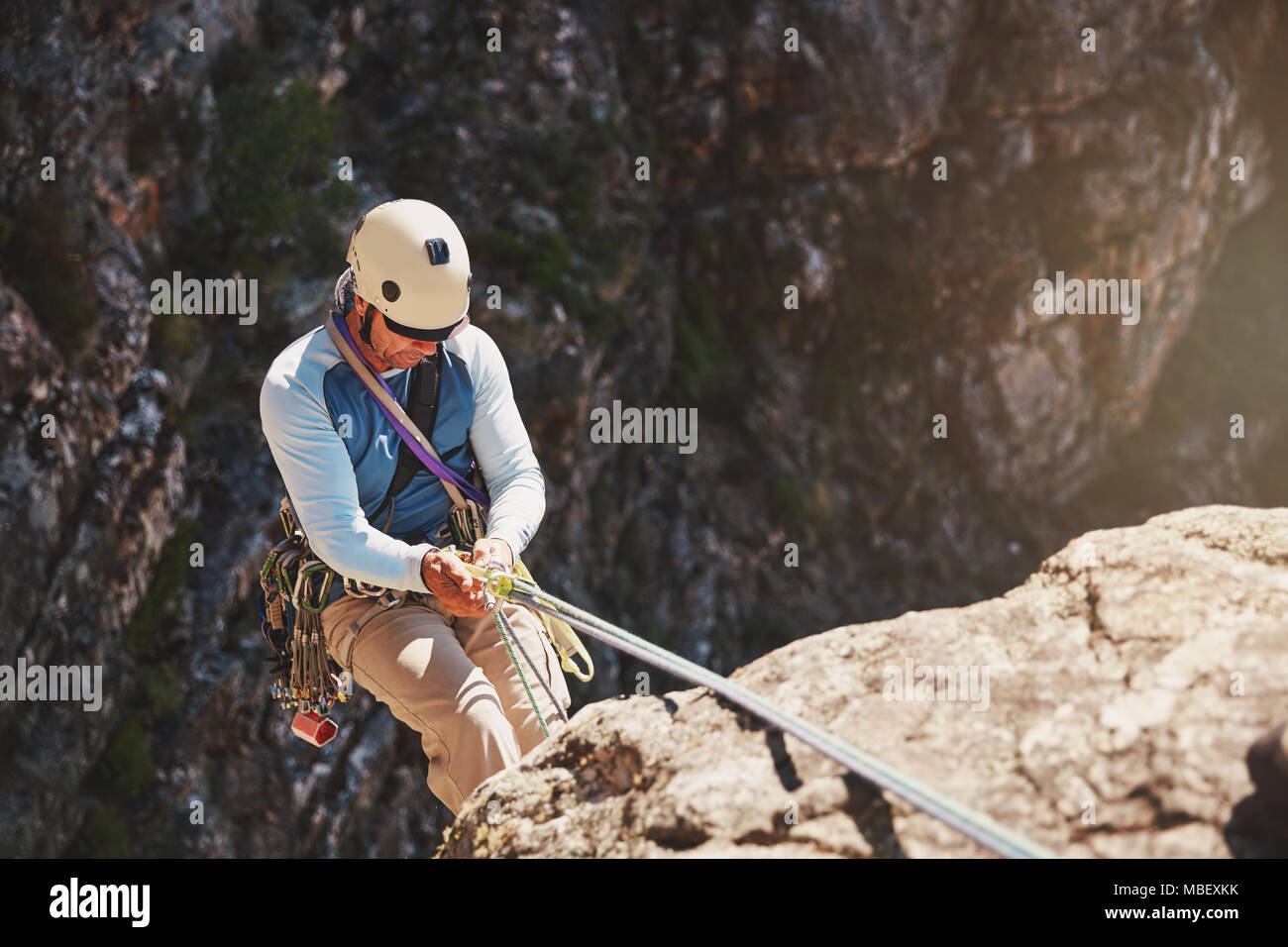Männliche Kletterer abseilen, absteigend von Seil Stockfoto