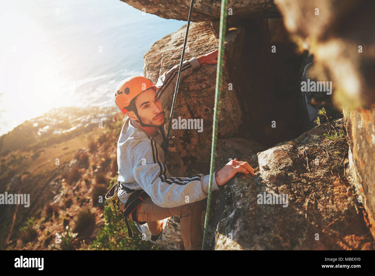 Fokussierte männliche Kletterer klettern Rock Stockfoto
