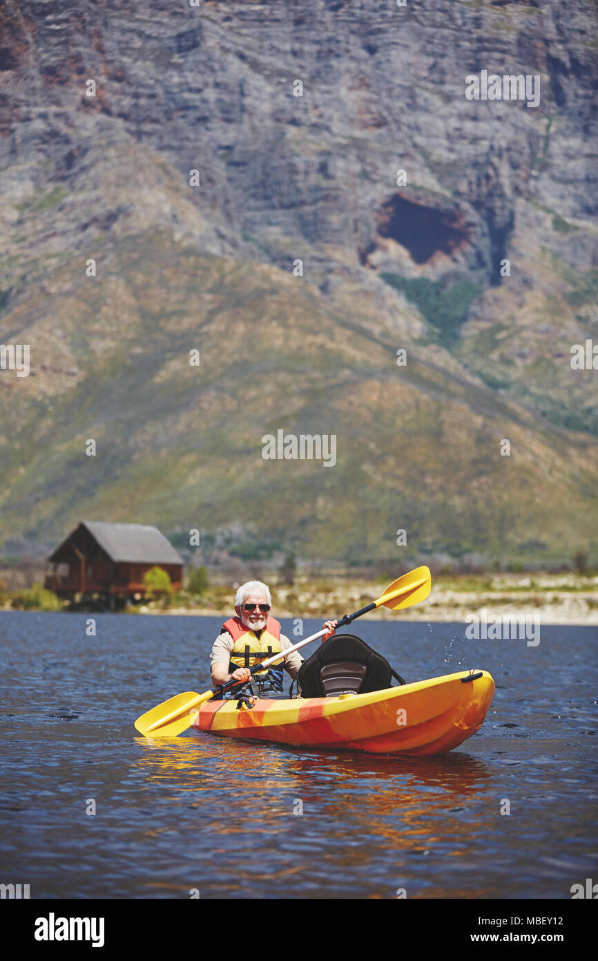 Active Senior mann Kajak auf sonnigen Sommer See Stockfoto