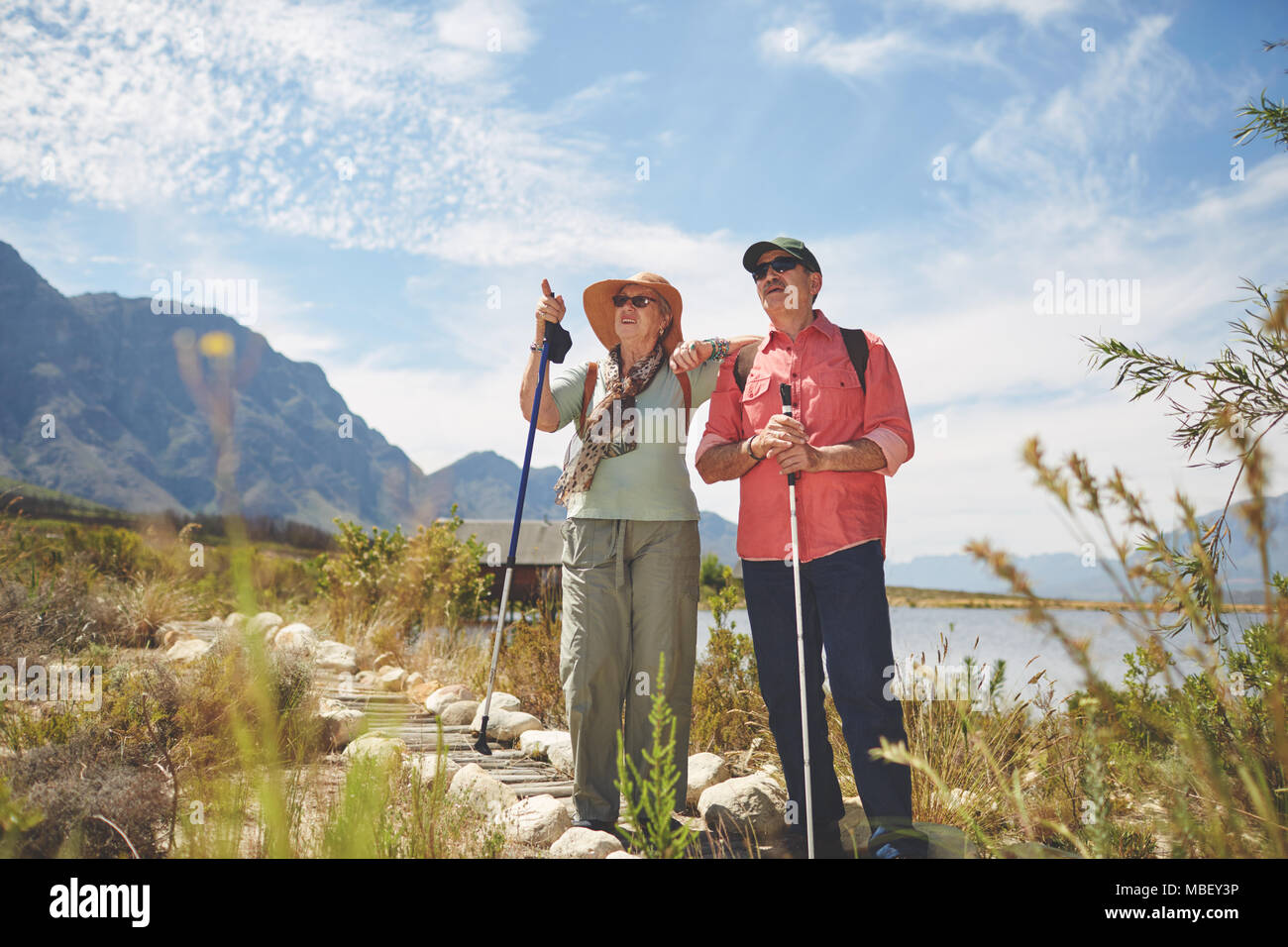 Active Senior Paar wandern mit wanderstöcken an sonnigen Sommer am See Stockfoto