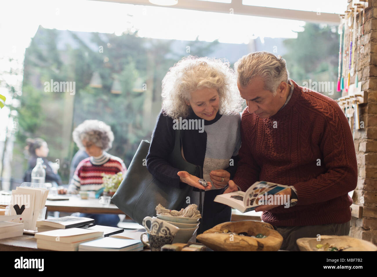 Senior Paar an Buchen Sie im Shop suchen Stockfoto