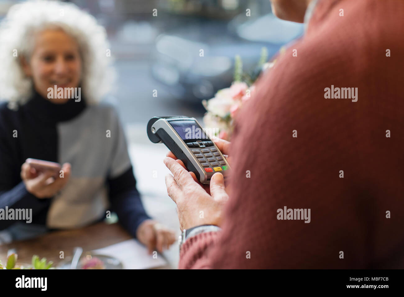 Kassierer mit Kreditkarte Maschine bereit für kontaktloses Bezahlen Stockfoto