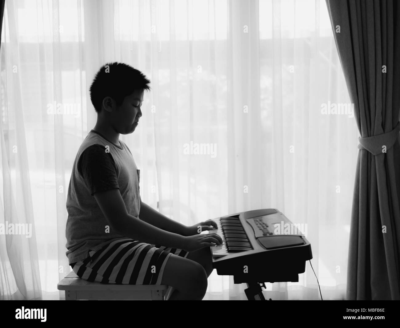 Asiatische Junge spielt Keyboard Piano zu Hause, Lifestyle Konzept. Stockfoto