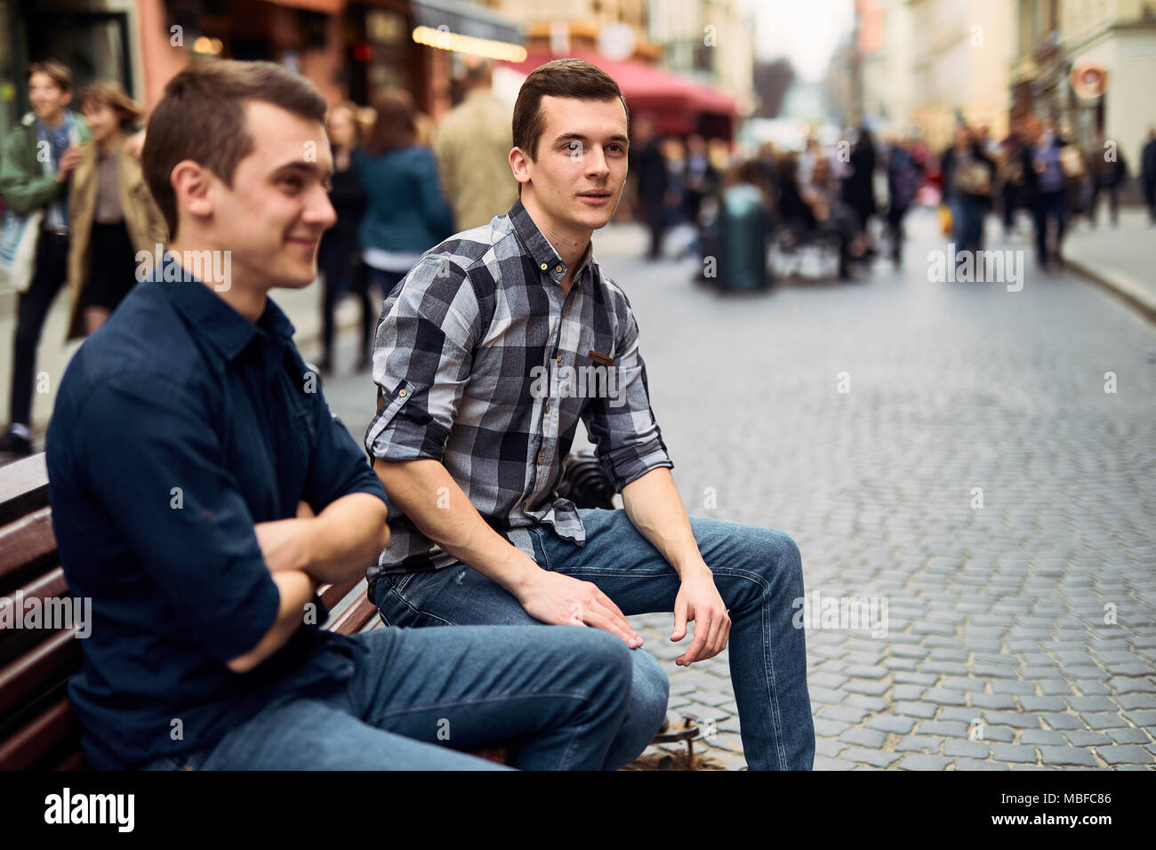 Zwei Mann auf der Bank und sprechen Sie auf der Straße sitzen Stockfoto