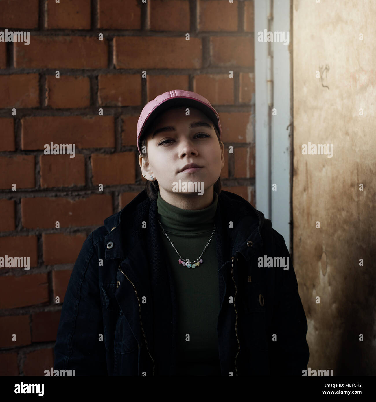 Ein Portrait eines Mädchens in einer schwarzen Jacke und einer pink Baseball Cap. Minsk, Weißrussland. Stockfoto