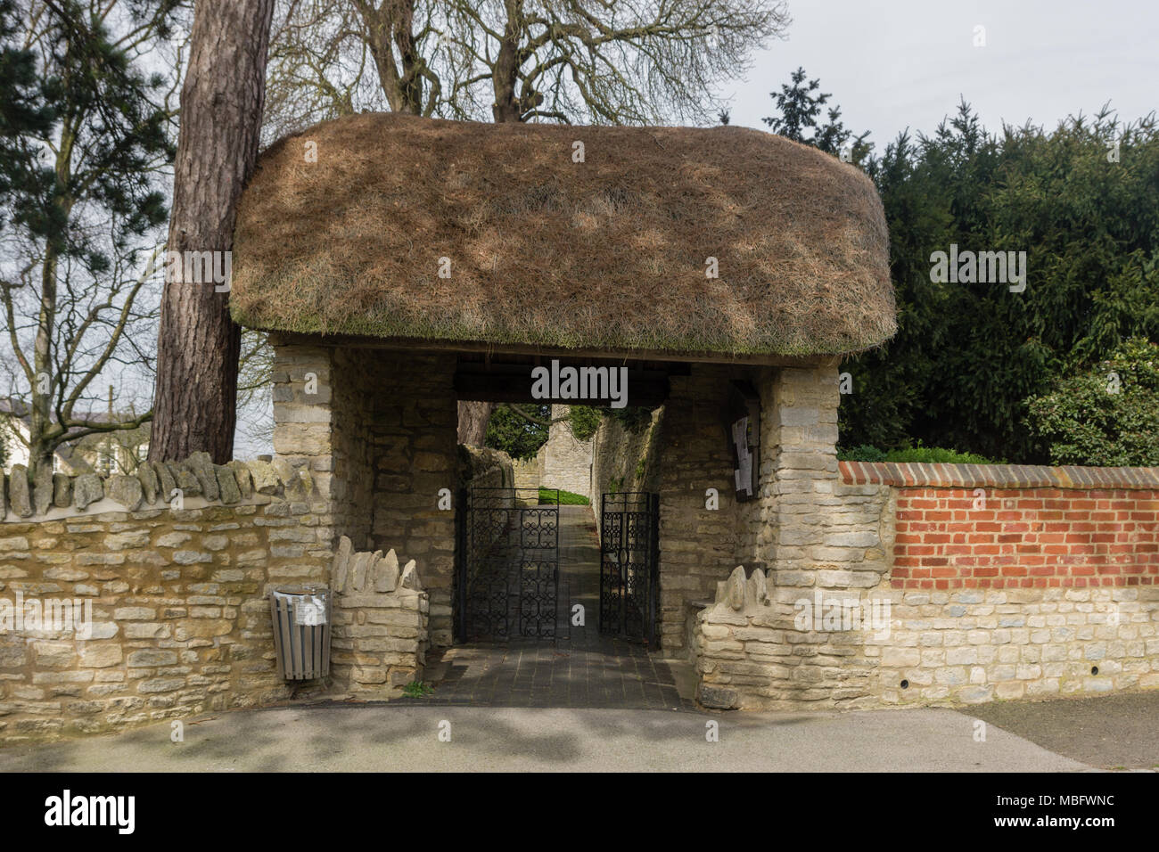 Reetgedeckte Eingang zum Friedhof aller Heiligen in der Ortschaft Ravenstone, Buckinghamshire, Großbritannien Stockfoto