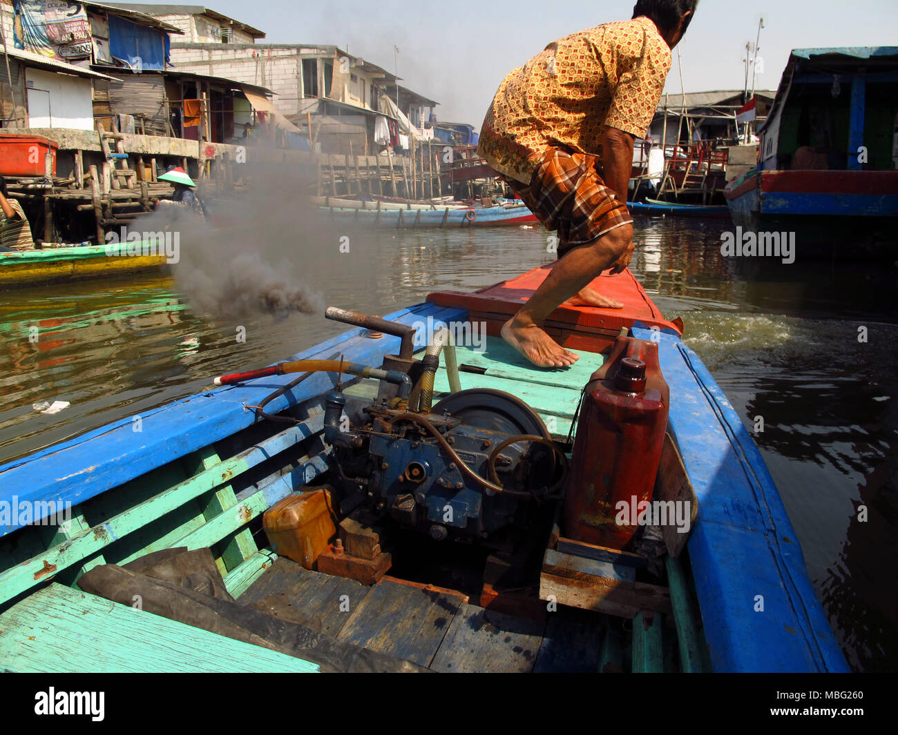 Der Mensch seine stinkenden Boot beginnend in den Flüssen von Jakarta Stockfoto