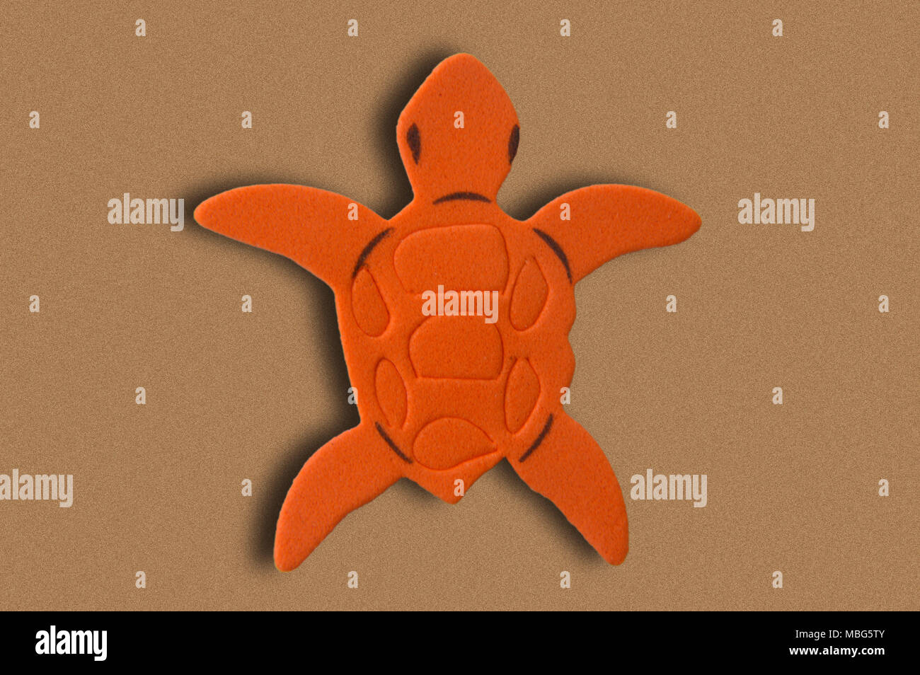 Eine orange turtle Gummi Eva auf gemalten Hintergrund imitieren Sand Stockfoto