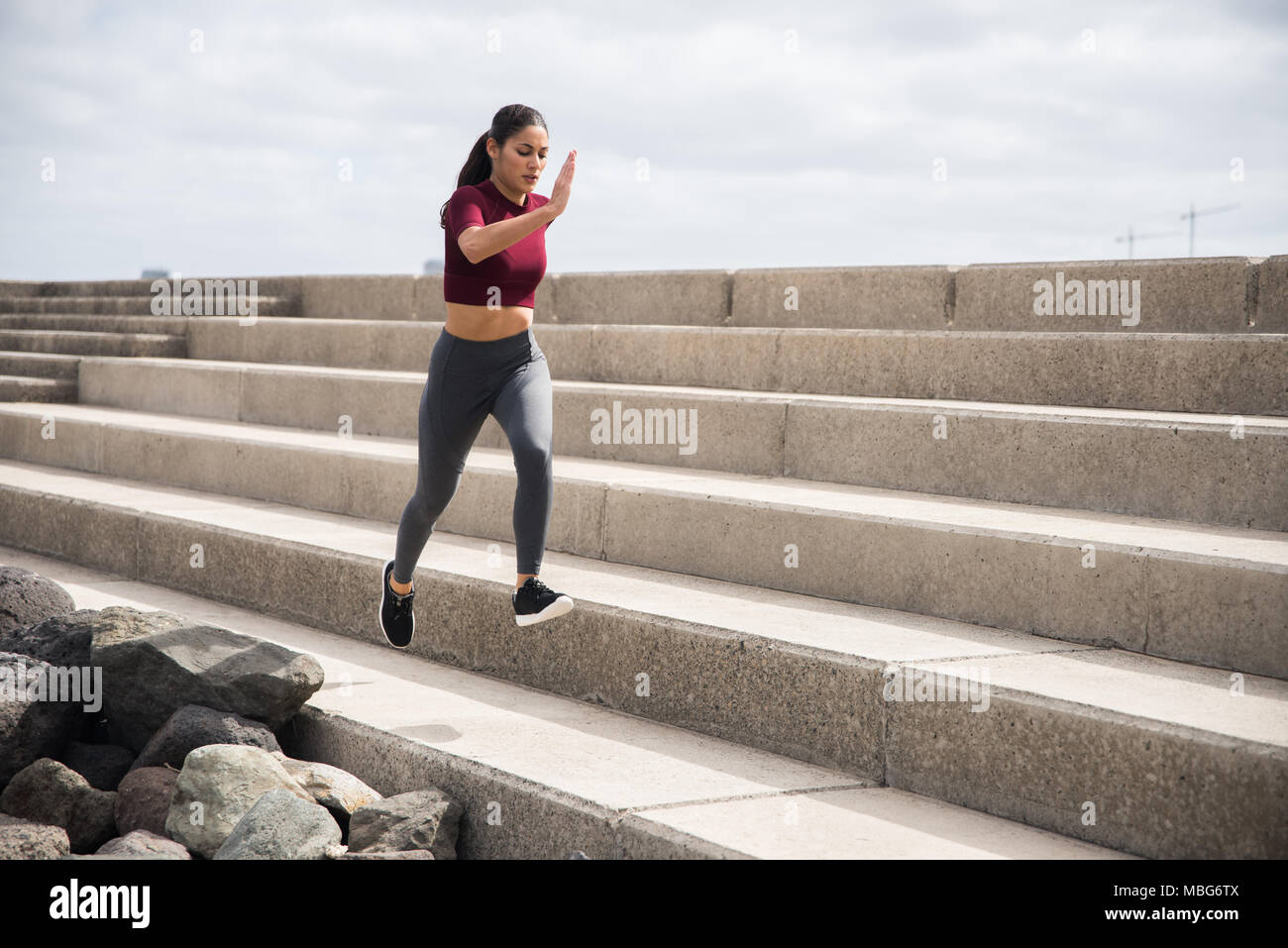 Junge hübsche Brünette tun Fitness auf Treppen in Sportkleidung und Sportschuhe Stockfoto