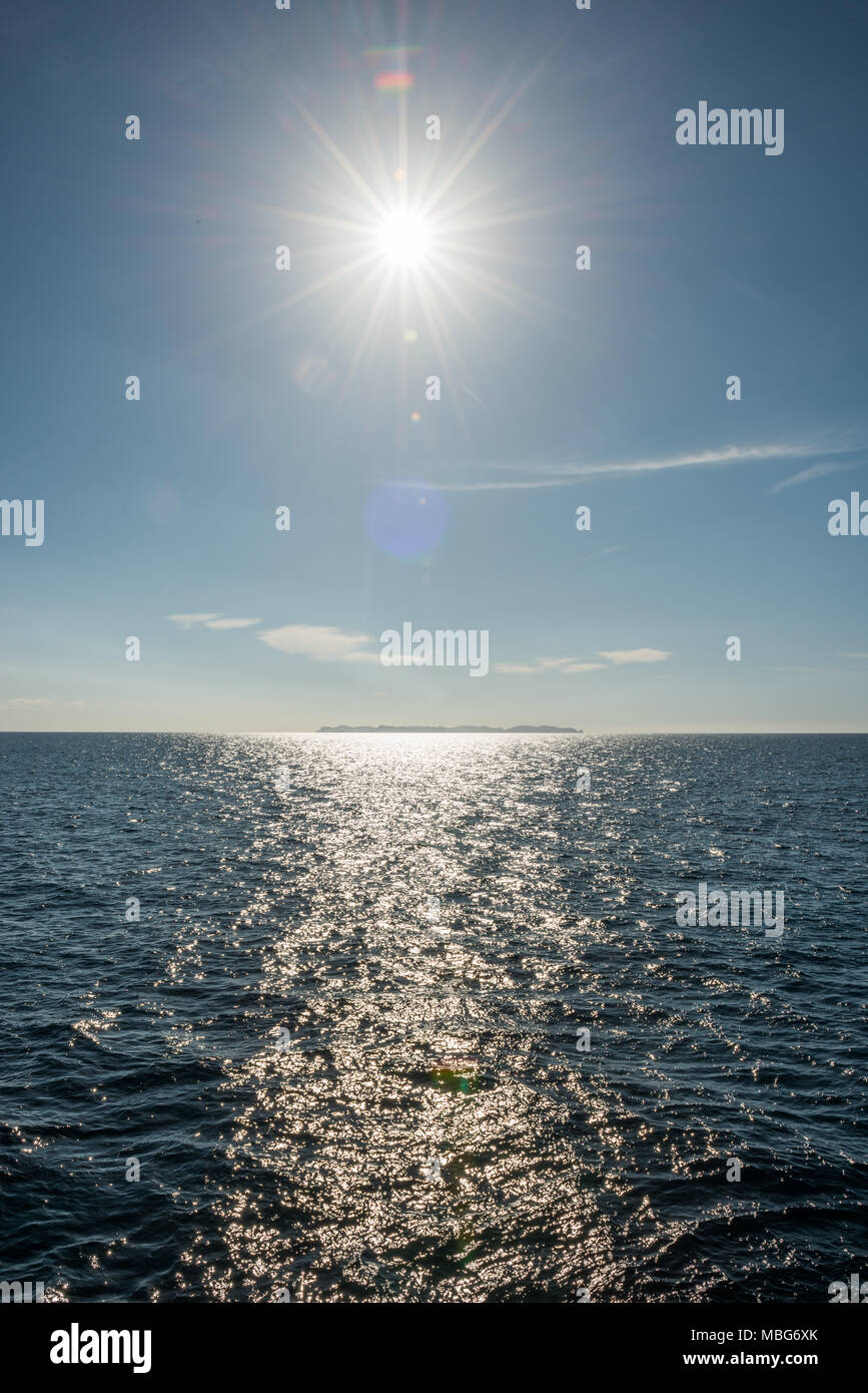 Reflexion der Sonne und die Insel Cabrera am Horizont im Mittelmeer in der Nähe von Colonia de Sant Jordi auf Mallorca, Spanien. Stockfoto