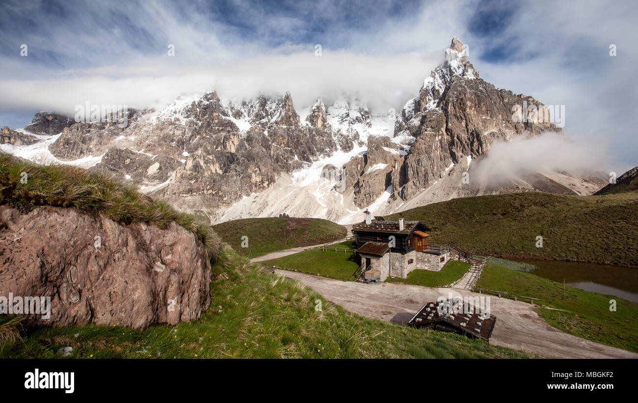 Cimon della Pala (auch genannt "Das Matterhorn der Dolomiten") mit schneebedeckten Gipfeln an einem sonnigen Tag mit dramatischen Wolken über. San Martino di Cas Stockfoto