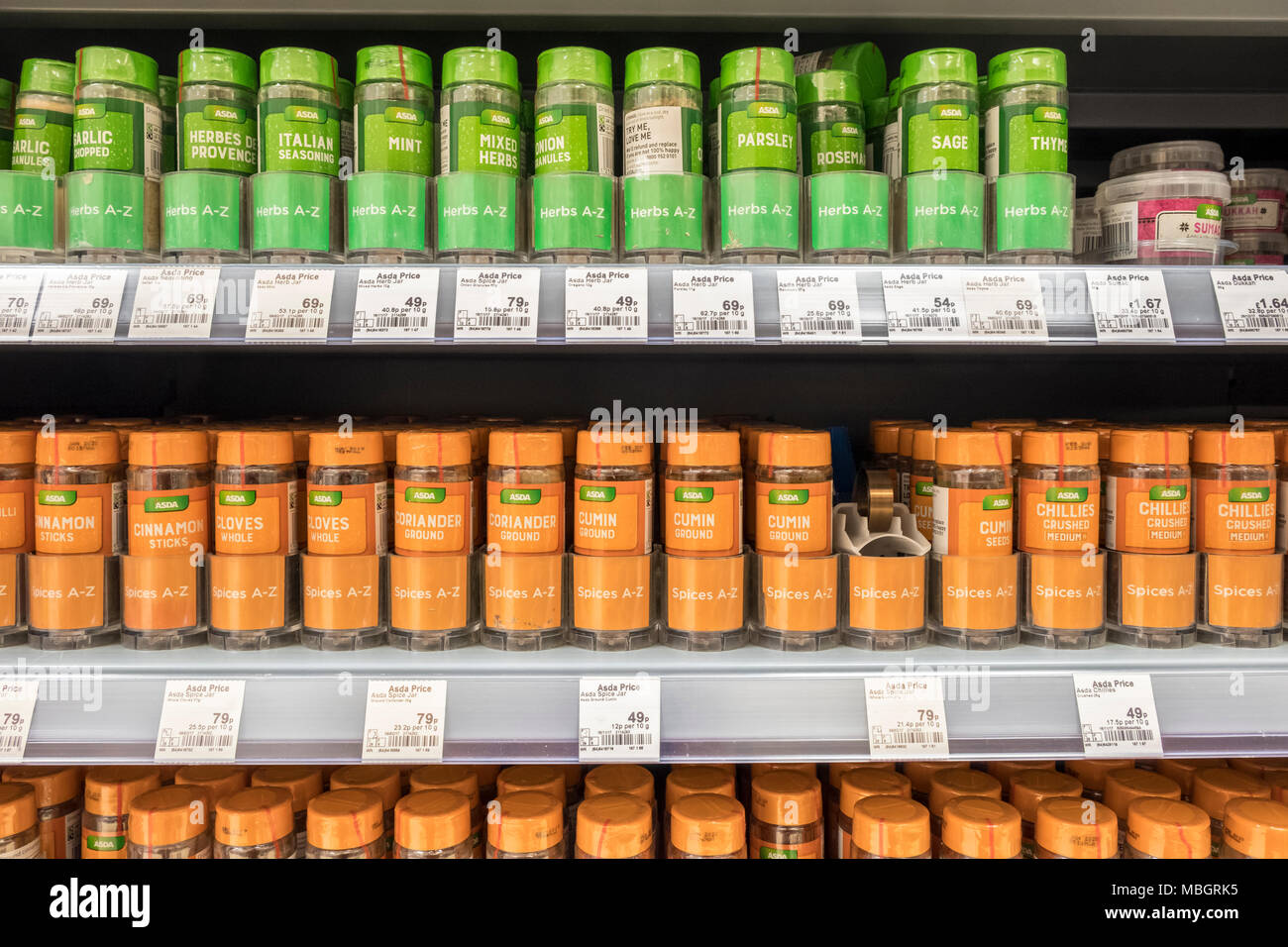 Gläser der eigenen Marke Kräuter und Gewürze in den Regalen der Supermärkte in Uk Supermarkt, Asda. Stockfoto