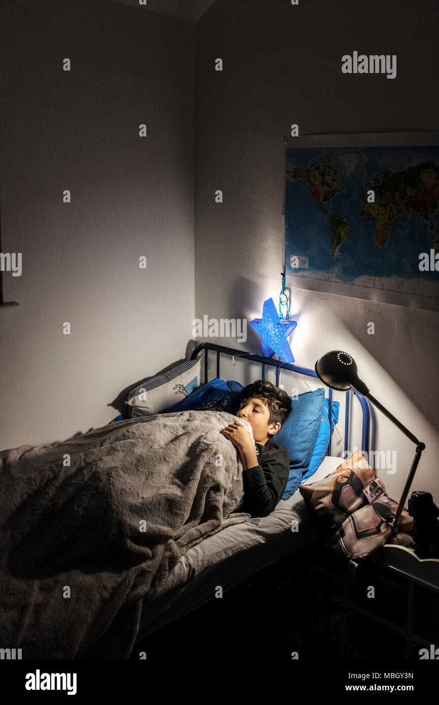 Junge, 10 Jahre alt, schläft in seinem Zimmer mit Licht an, UK, Surrey Stockfoto