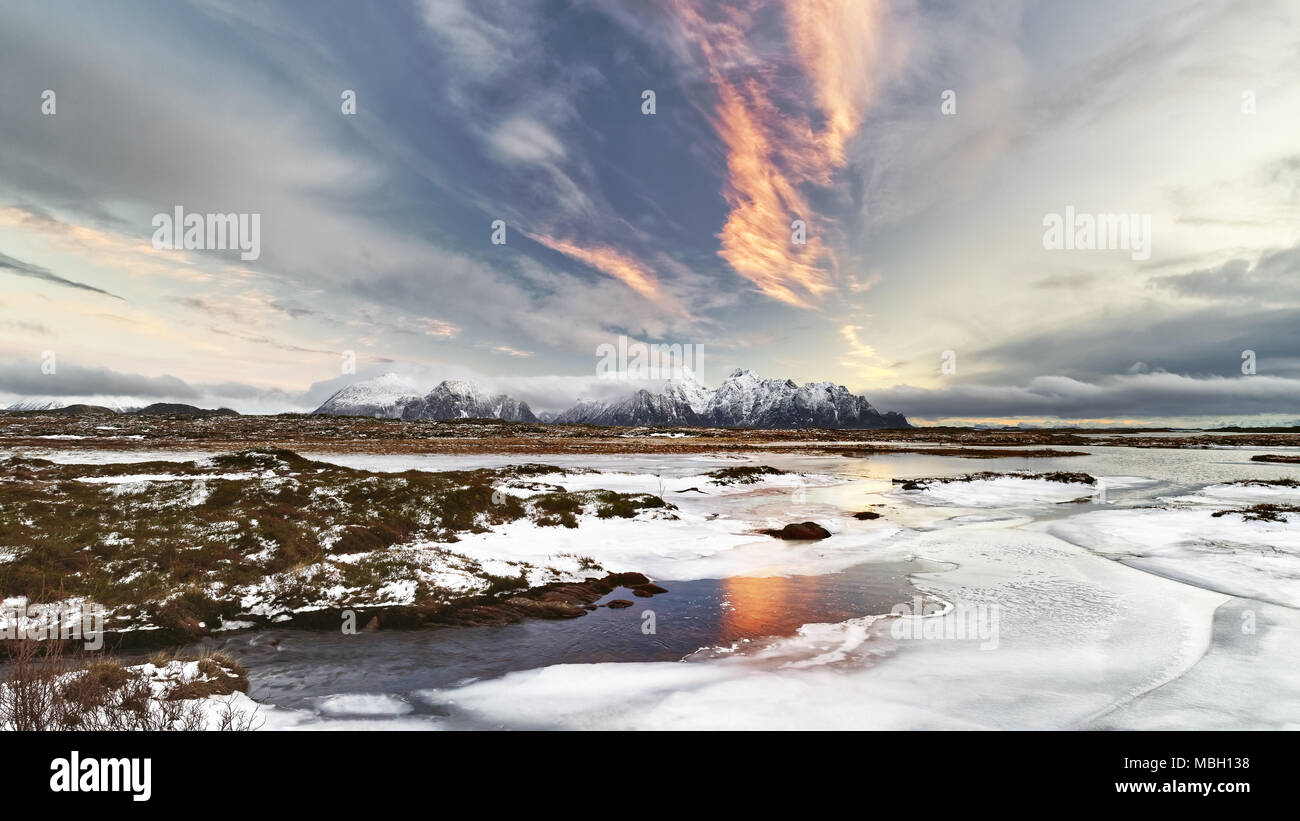 Eis Landschaft mit Bergen im Hintergrund und Red Cloud Formation mit Reflexion - Ort: Norwegen, Lofoten Stockfoto