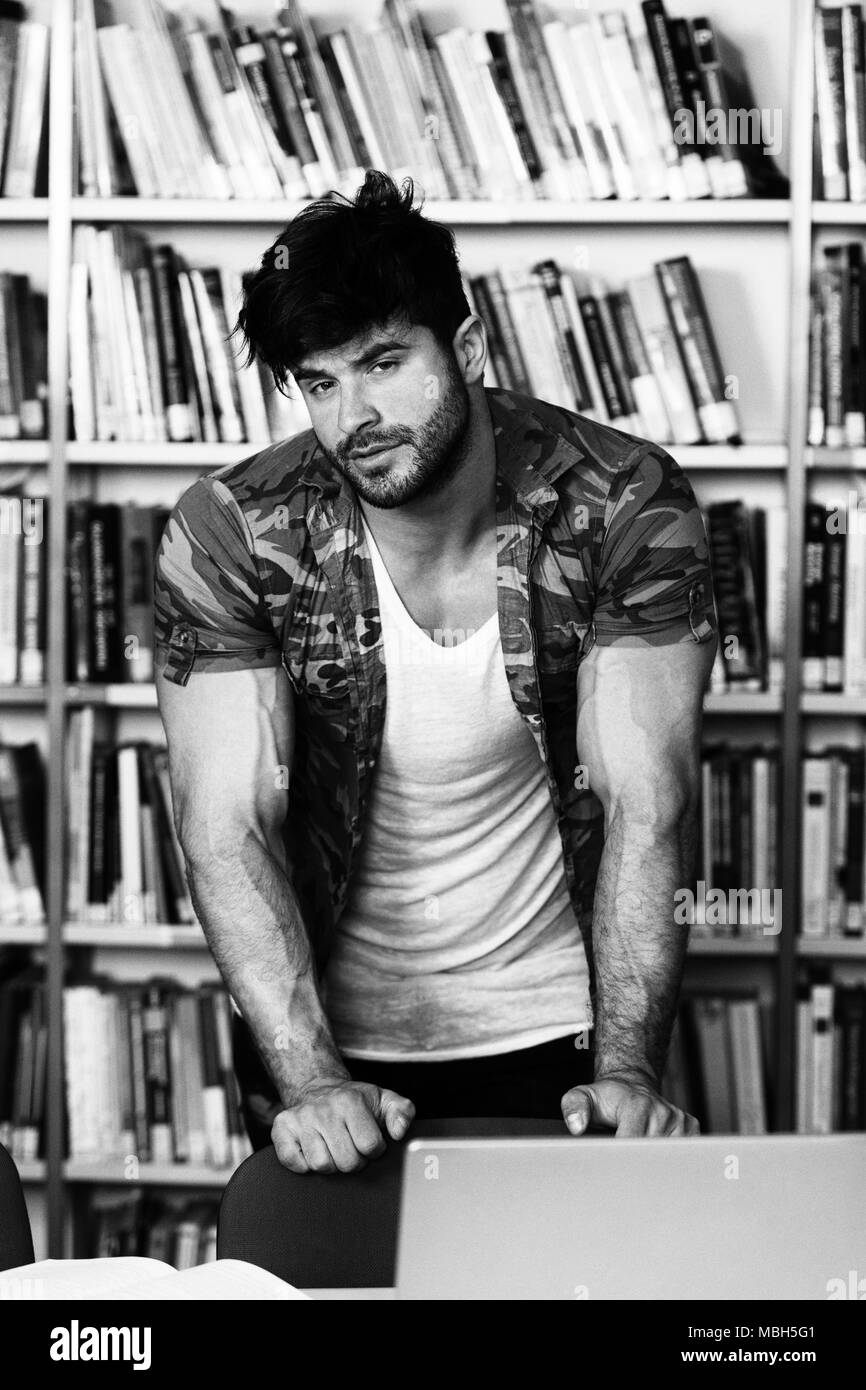 Athletic Fitness männliche Kursteilnehmer mit Büchern Arbeiten in einer High School Bibliothek Stockfoto