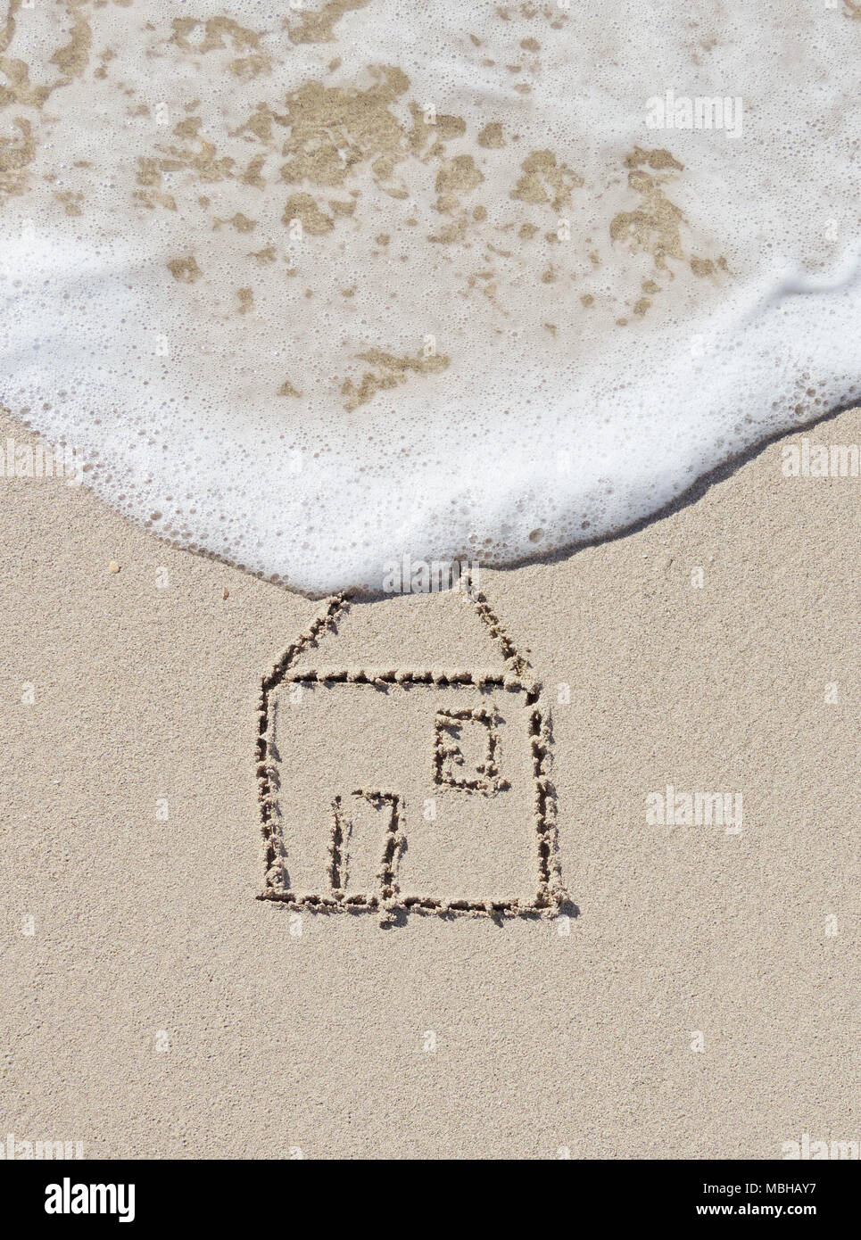 Haus zeichnen in den Sand. Sand und Meer Szene mit Surf- und Haus-symbol. Stockfoto