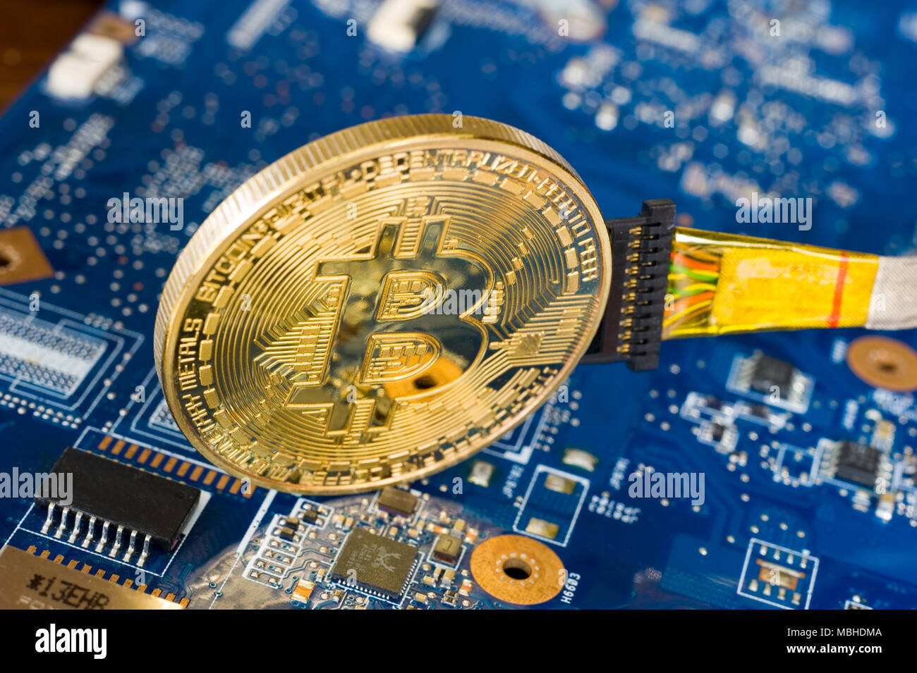Kabelgebundene bitcoin stehend auf dem elektronischen Hauptplatine eines Laptop Stockfoto