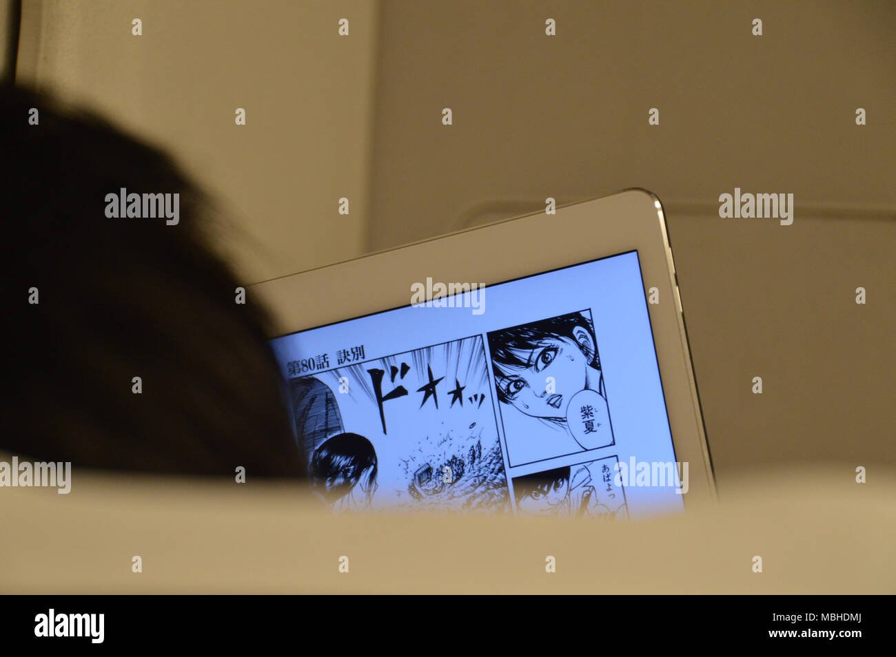 Person lesen Manga zu einem Tablet Stockfoto